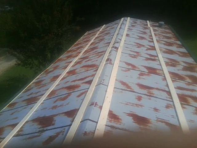 Rusted metal roof panels with new wood purlins before replacement — Storm Damage Roof Repair in Cliff Island by Roofing Brothers