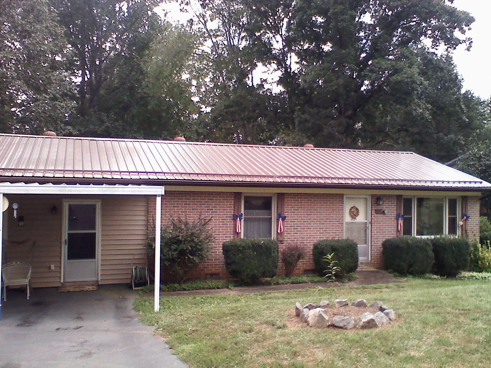 Bronze metal roof and carport on a brick ranch home — Roof Repair work by our crew in Cliff Island